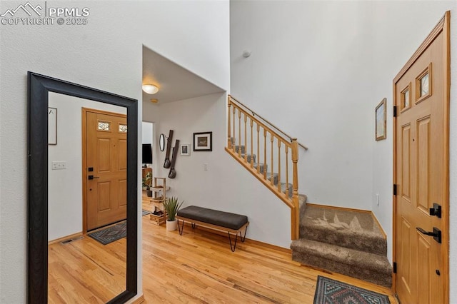 921 Cottonwood Lake Dr, Divide, CO 80814 - foyer entrance featuring stairs, light wood finished floors, a towering ceiling, and baseboards