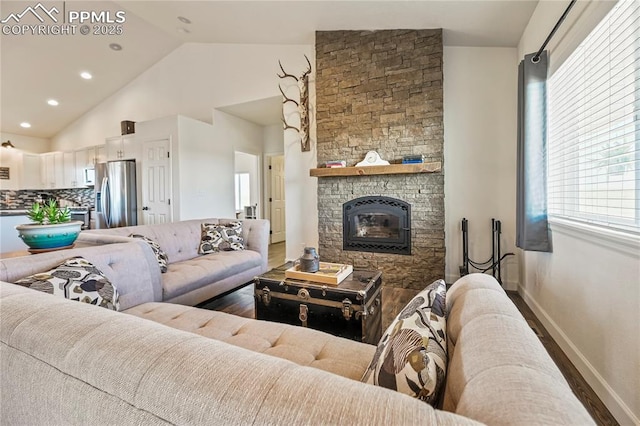 living room featuring wood finished floors, baseboards, a fireplace, and high vaulted ceiling