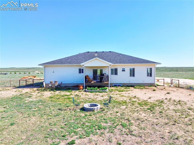 back of property featuring an outdoor fire pit, fence, a wooden deck, and a view of rural / pastoral area