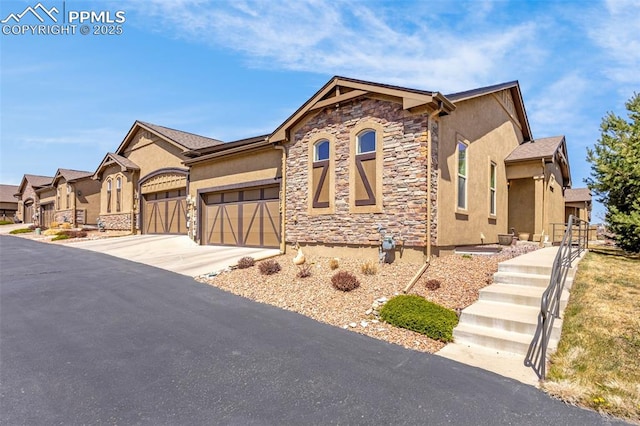 7674 Double Barrel Hts, Colorado Springs, CO 80923 - view of front facade with stone siding, stucco siding, a garage, concrete driveway, and fence