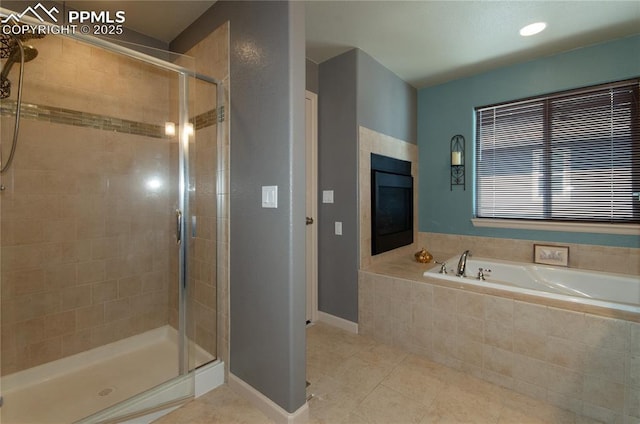 13574 Park Gate Dr, Peyton, CO 80831 - bathroom featuring a shower stall, tile patterned flooring, a bath, a fireplace, and baseboards