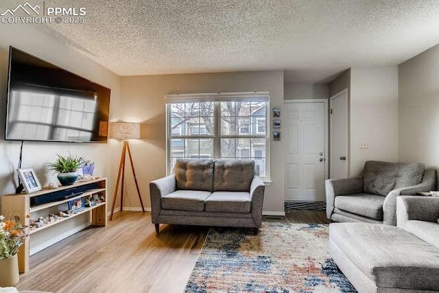 7911 Lexington Park Dr, Colorado Springs, CO 80920 - living area featuring a textured ceiling, wood finished floors, and baseboards