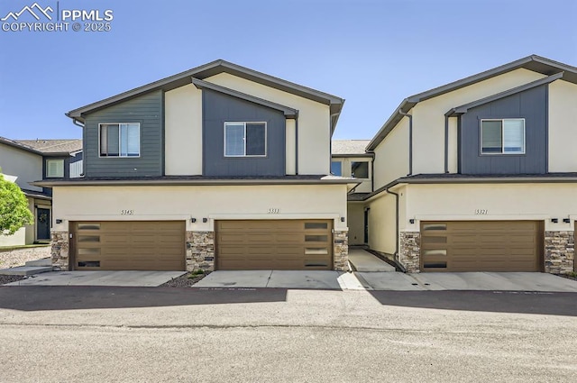 view of front facade featuring stone siding, a garage, and stucco siding
