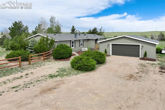 ranch-style home with fence and a detached garage