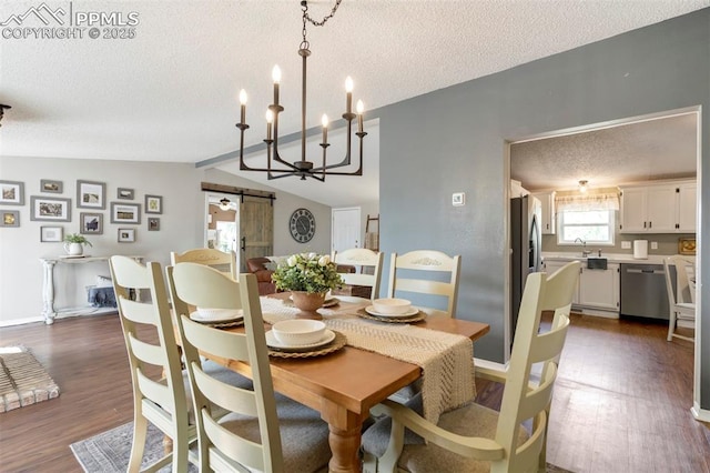 dining room with a barn door, a textured ceiling, dark wood-style floors, vaulted ceiling, and baseboards
