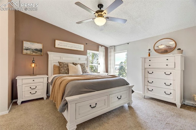 bedroom with a textured ceiling, lofted ceiling, light colored carpet, baseboards, and a ceiling fan