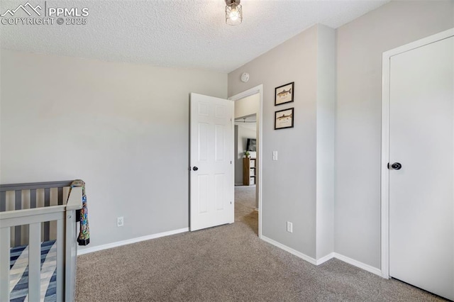 bedroom featuring carpet flooring, a textured ceiling, and baseboards