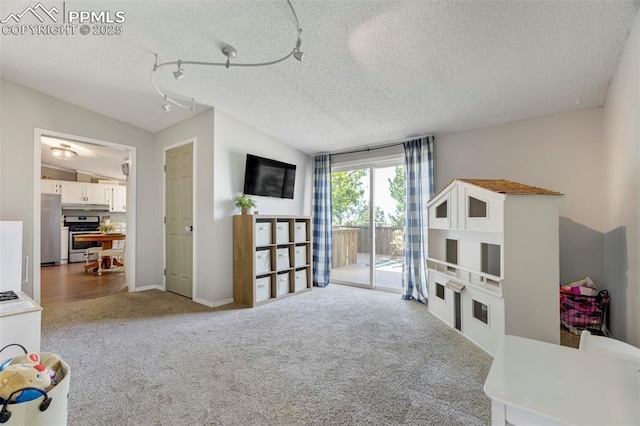 playroom with carpet flooring, a textured ceiling, and lofted ceiling