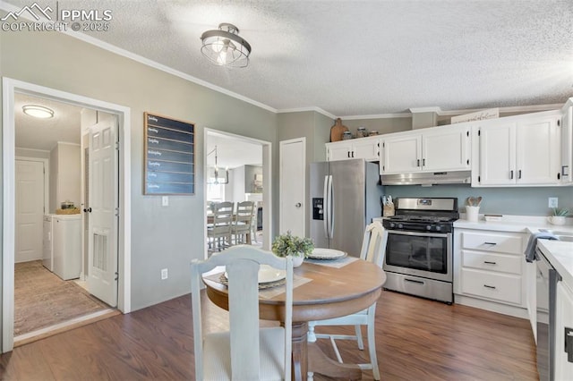 kitchen with appliances with stainless steel finishes, under cabinet range hood, a textured ceiling, white cabinets, and wood finished floors