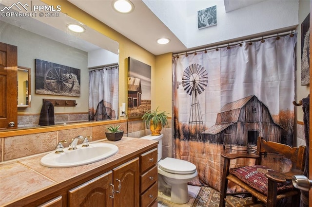18045 Woodhaven Pl, Colorado Springs, CO 80908 - bathroom with tile walls, toilet, vanity, and recessed lighting