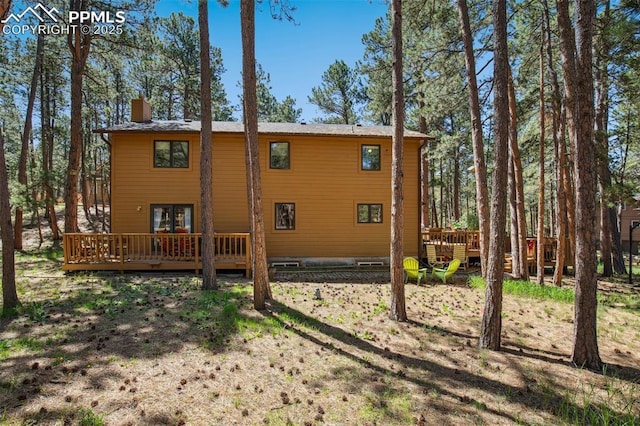 18045 Woodhaven Pl, Colorado Springs, CO 80908 - back of property with a wooden deck and a chimney