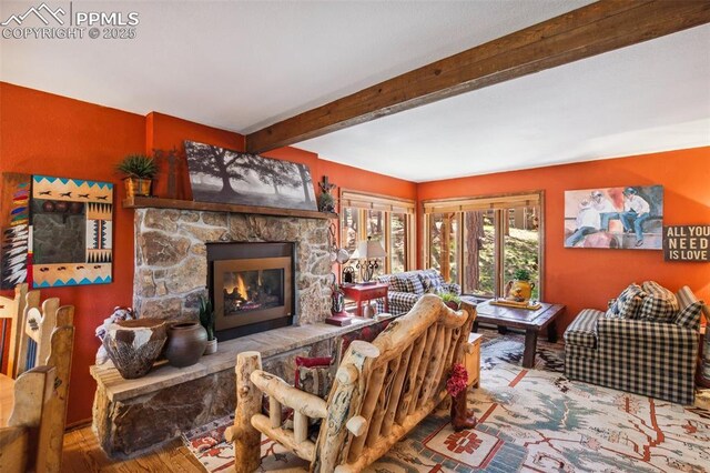 18045 Woodhaven Pl, Colorado Springs, CO 80908 - living area with beam ceiling, a stone fireplace, and wood finished floors