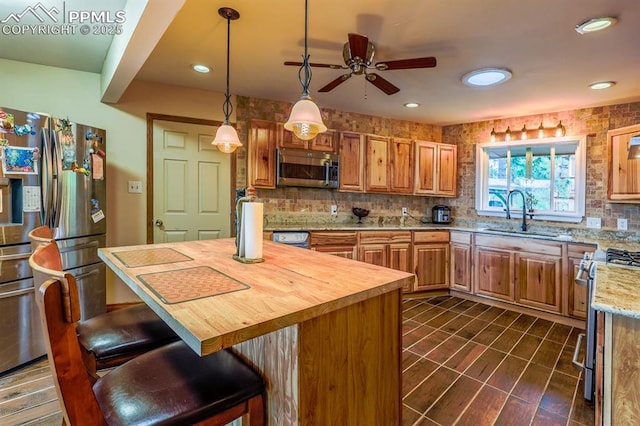 2760 Evergreen Rd, Colorado Springs, CO 80921 - kitchen with a sink, stainless steel appliances, a ceiling fan, wooden counters, and backsplash