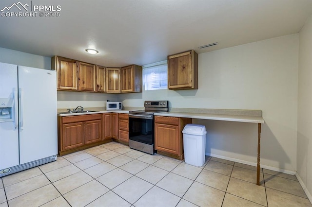 2760 Evergreen Rd, Colorado Springs, CO 80921 - kitchen with appliances with stainless steel finishes, brown cabinetry, light countertops, a sink, and light tile patterned floors