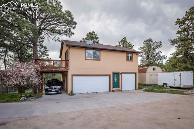 2760 Evergreen Rd, Colorado Springs, CO 80921 - back of property featuring a garage, stucco siding, driveway, and a deck