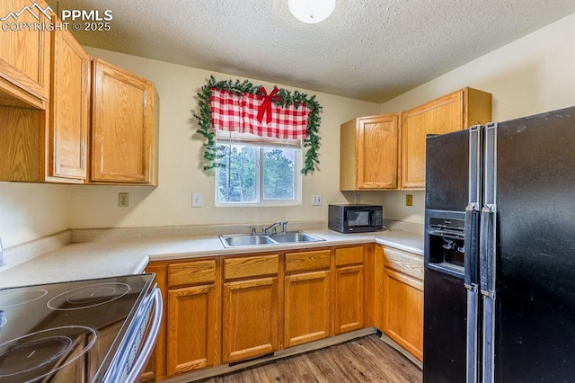 2760 Evergreen Rd, Colorado Springs, CO 80921 - kitchen with black appliances, a sink, a textured ceiling, light countertops, and wood finished floors