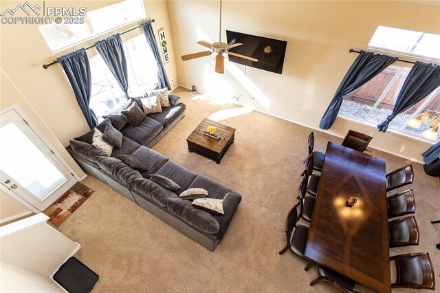carpeted living area with ceiling fan