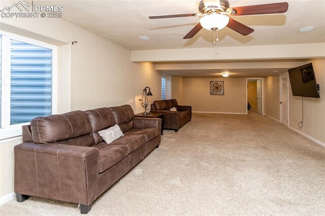living room featuring light carpet, baseboards, and a ceiling fan