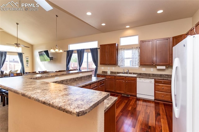 kitchen with white appliances, a sink, plenty of natural light, dark wood-type flooring, and lofted ceiling