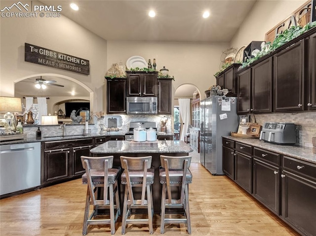 kitchen with appliances with stainless steel finishes, a sink, tasteful backsplash, a center island, and recessed lighting