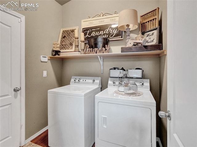laundry room featuring washer and dryer, baseboards, and wood finished floors