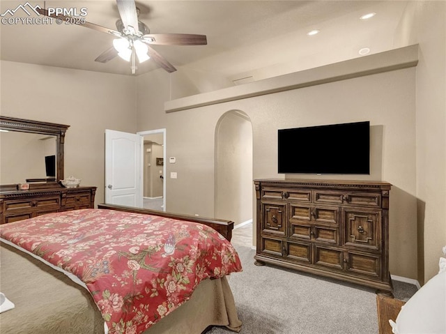 bedroom featuring carpet, arched walkways, lofted ceiling, baseboards, and ceiling fan