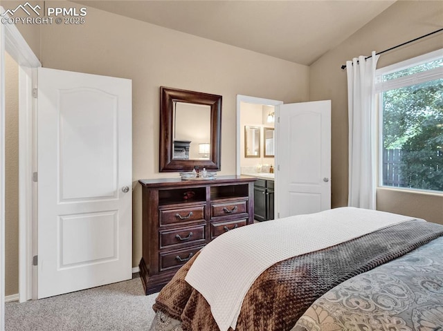 carpeted bedroom featuring vaulted ceiling, baseboards, and connected bathroom