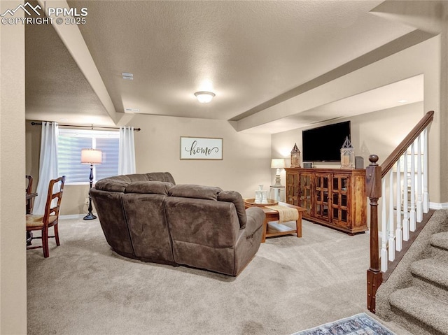 carpeted living room with baseboards, stairs, and a textured ceiling