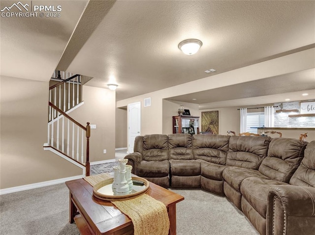 carpeted living room featuring stairway, baseboards, and a textured ceiling