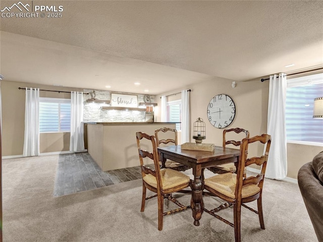 dining area with light carpet, a textured ceiling, baseboards, and recessed lighting