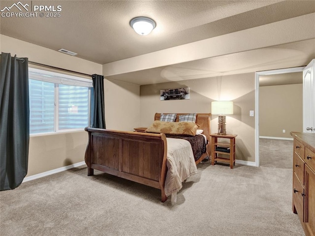 bedroom featuring light colored carpet, baseboards, and a textured ceiling