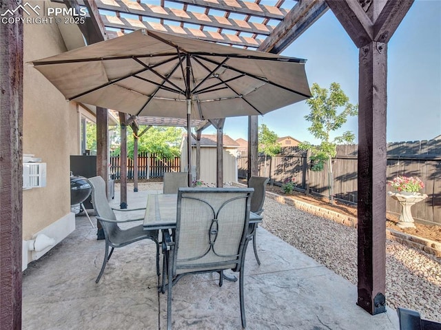 view of patio with outdoor dining space, a fenced backyard, a pergola, a storage unit, and an outdoor structure