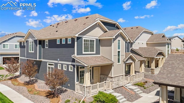 view of home's exterior with stone siding, a shingled roof, and a residential view