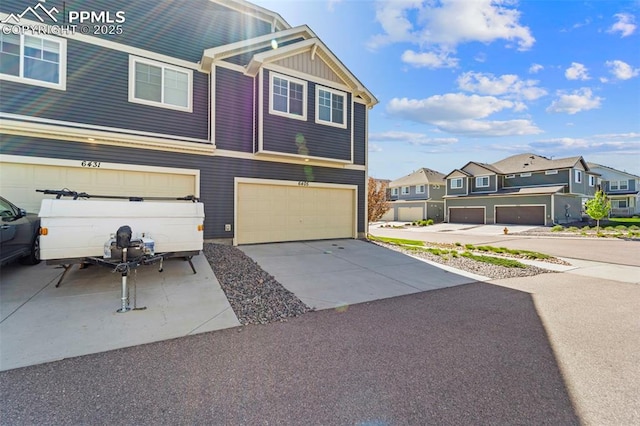 view of property with a garage, a residential view, board and batten siding, and driveway