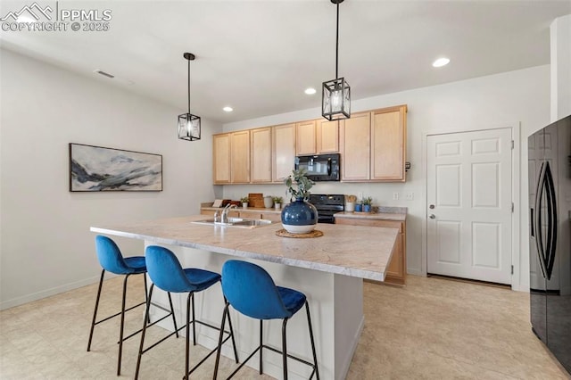 kitchen with black appliances, light brown cabinets, a sink, recessed lighting, and a kitchen bar