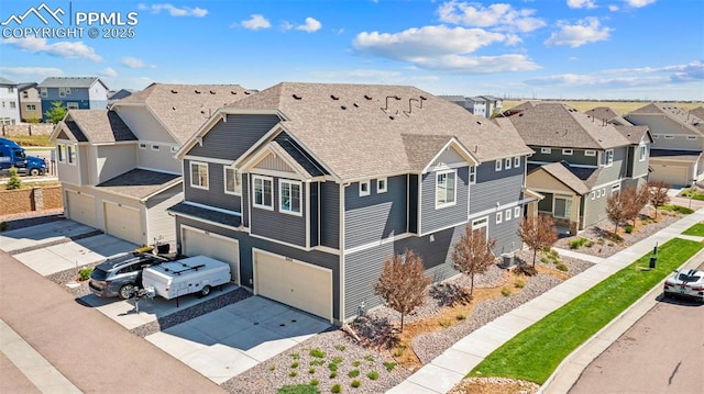 view of front of property with a residential view, an attached garage, driveway, and a shingled roof