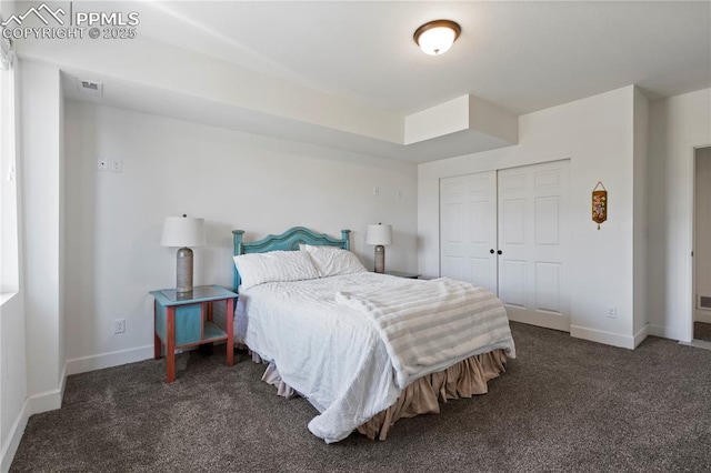 carpeted bedroom featuring baseboards and a closet