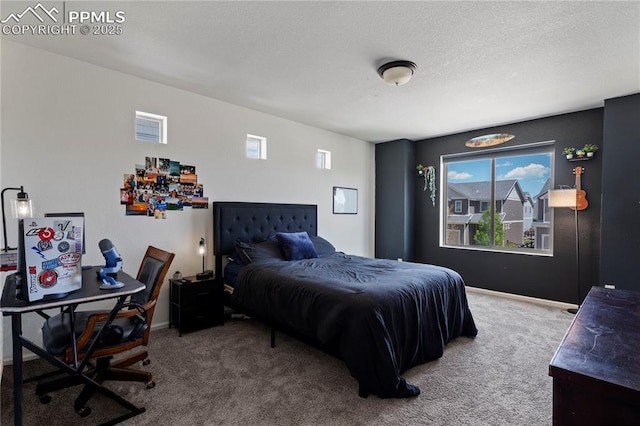 carpeted bedroom with an office area, baseboards, and a textured ceiling