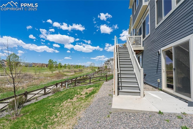 fenced backyard featuring stairs and a patio