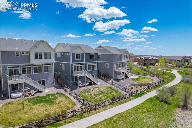 rear view of property featuring a residential view, stairs, a fenced backyard, and a deck