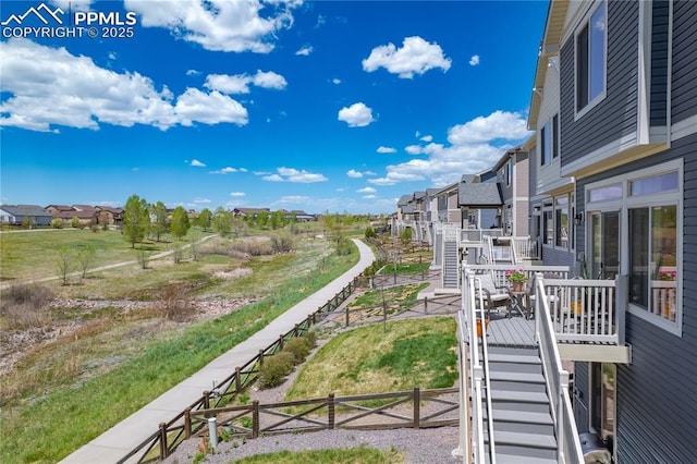 view of wooden balcony featuring stairway, a wooden deck, and a residential view