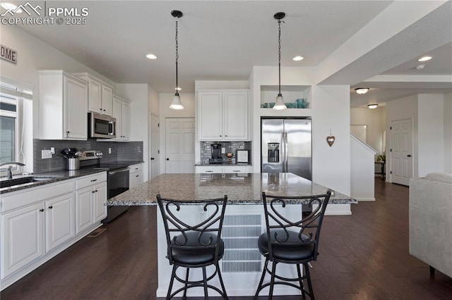 kitchen with stainless steel appliances, dark wood finished floors, a breakfast bar area, tasteful backsplash, and recessed lighting