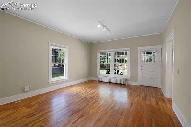 1505 Cheyenne Blvd, Colorado Springs, CO 80906 - empty room with radiator heating unit, ornamental molding, rail lighting, wood finished floors, and plenty of natural light