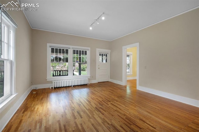 1505 Cheyenne Blvd, Colorado Springs, CO 80906 - unfurnished room featuring radiator, rail lighting, wood finished floors, baseboards, and ornamental molding