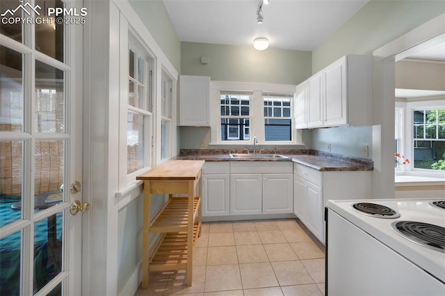 1505 Cheyenne Blvd, Colorado Springs, CO 80906 - kitchen featuring a sink, dark countertops, white cabinets, light tile patterned flooring, and white range with electric cooktop