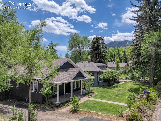 1505 Cheyenne Blvd, Colorado Springs, CO 80906 - view of front of home featuring a porch, a front lawn, a shingled roof, and a mountain view