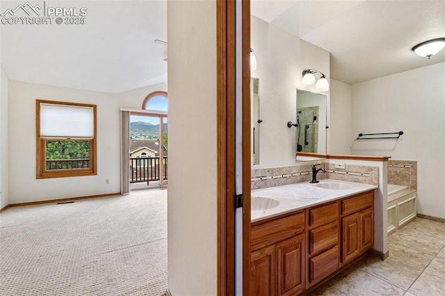 1433 Ledge Rock Ter, Colorado Springs, CO 80919 - bathroom featuring double vanity, a garden tub, baseboards, and decorative backsplash
