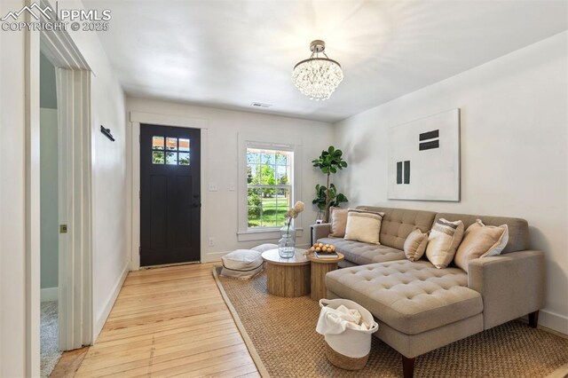 825 N Wahsatch Ave, Colorado Springs, CO 80903 - living room with light wood-style floors, a chandelier, and baseboards