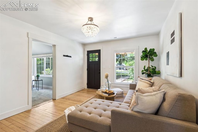 825 N Wahsatch Ave, Colorado Springs, CO 80903 - living area with light wood finished floors, plenty of natural light, a chandelier, and baseboards
