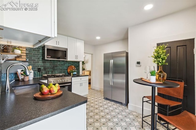 825 N Wahsatch Ave, Colorado Springs, CO 80903 - kitchen with stainless steel appliances, dark countertops, white cabinets, a sink, and light flooring